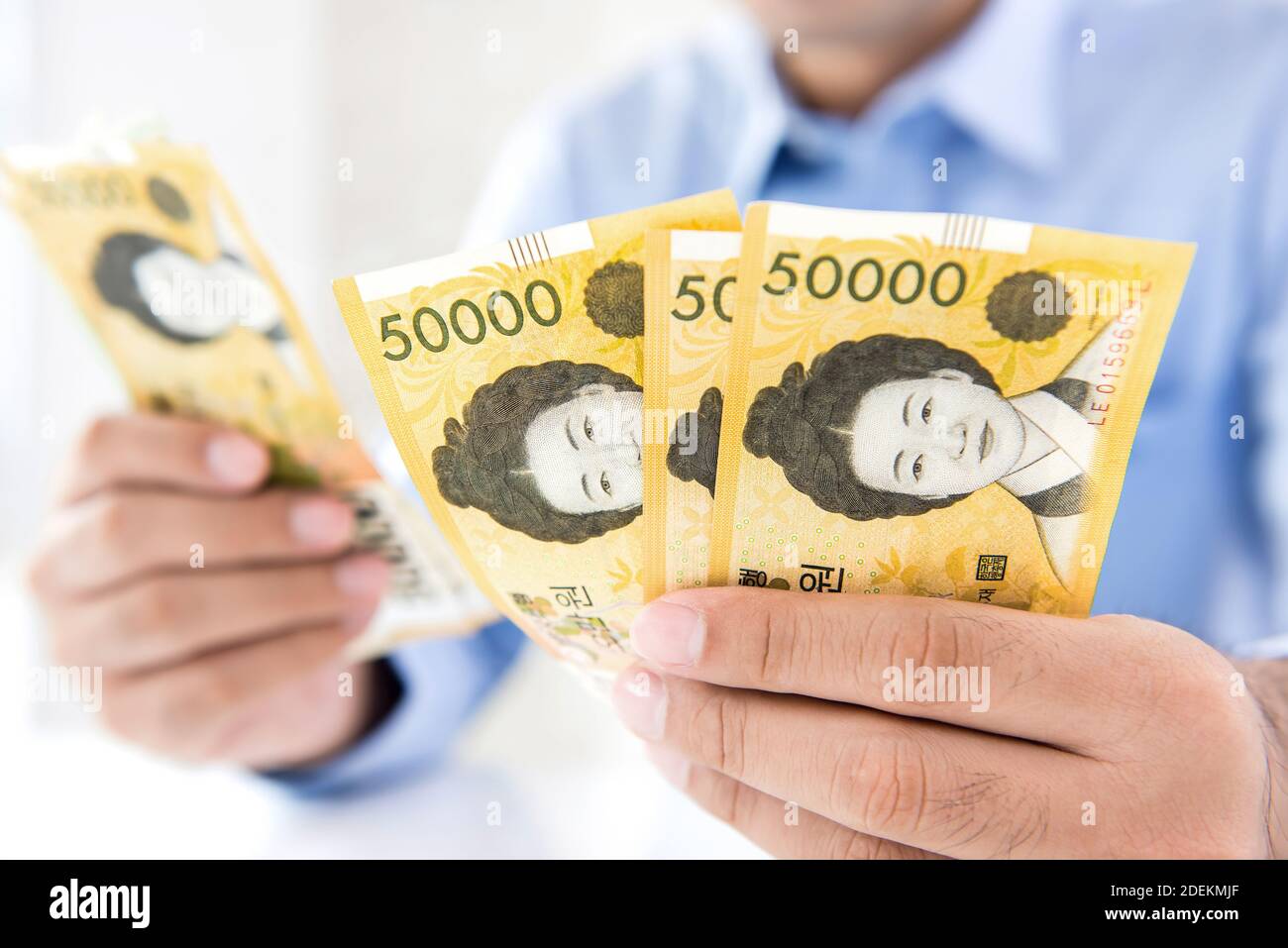 L'homme d'affaires comptant l'argent calculant le taux de conversion de la Corée du Sud a gagné billets entre ses mains Banque D'Images