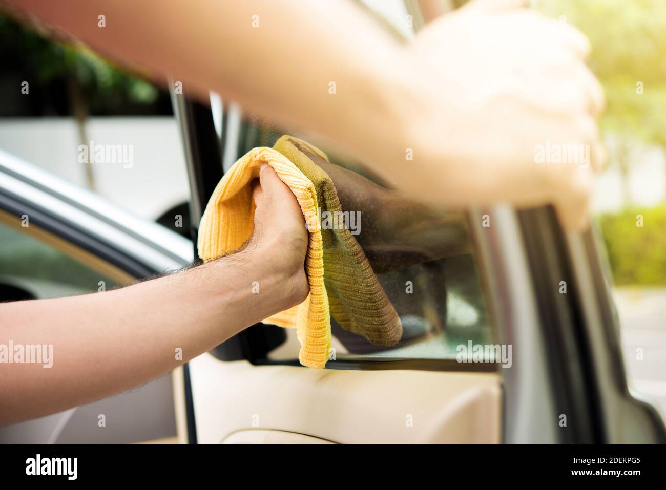 Le personnel du service entretien automobile nettoie les vitres de la voiture avec de la microfibre tissu Banque D'Images