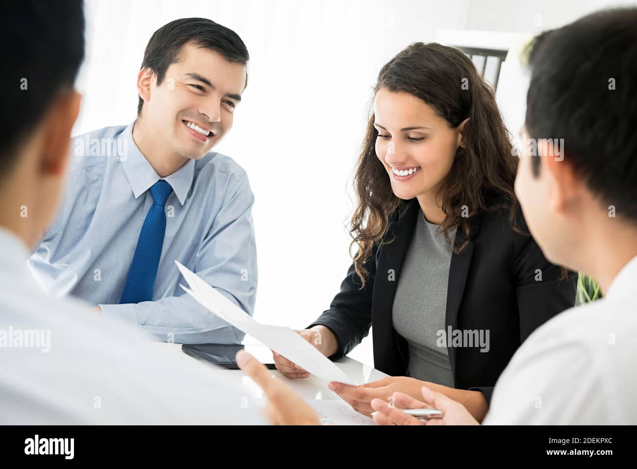 Bonne équipe d'affaires souriante discutant du document lors de la réunion à le bureau Banque D'Images