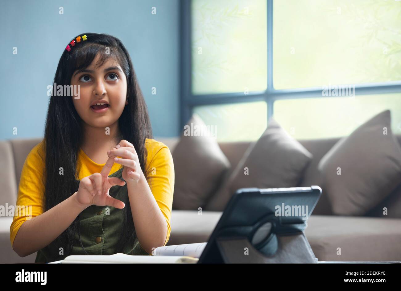 Mignonne fille essayant de résoudre un problème de mathématiques pendant elle cours en ligne à la maison Banque D'Images