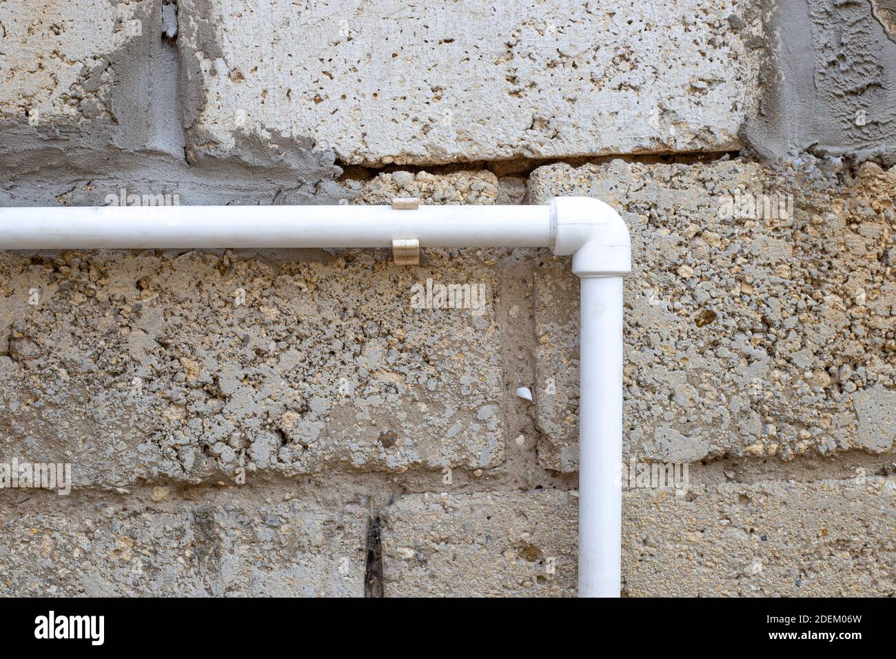 Tuyau d'eau en PVC blanc sur le fond d'un mur en pierre. Alimentation en  eau des bâtiments résidentiels Photo Stock - Alamy