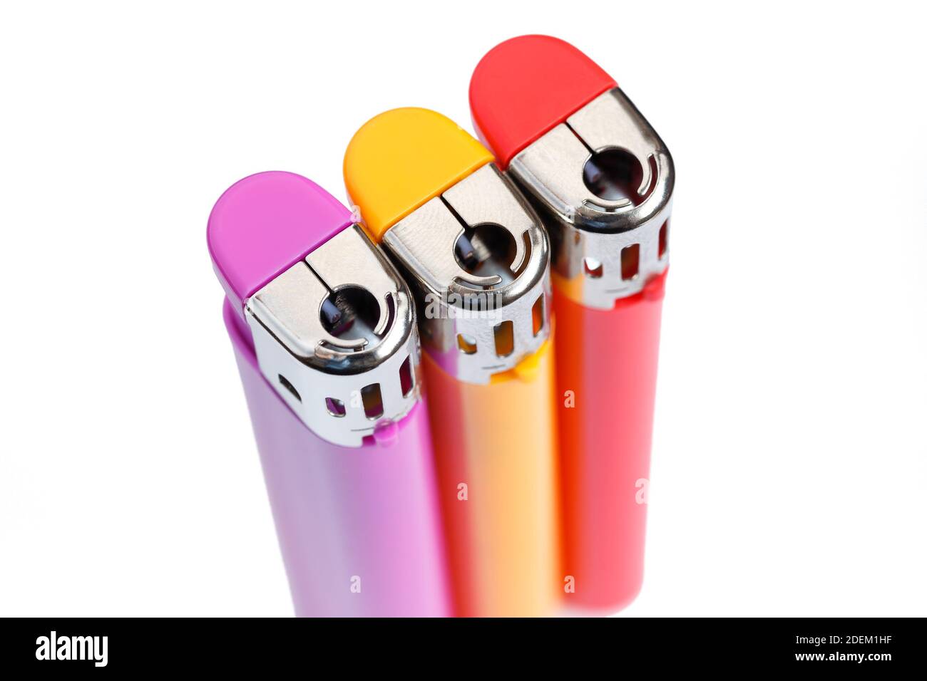 Trois briquets de gaz multicolores sur fond blanc isolés. Vue de dessus. Banque D'Images