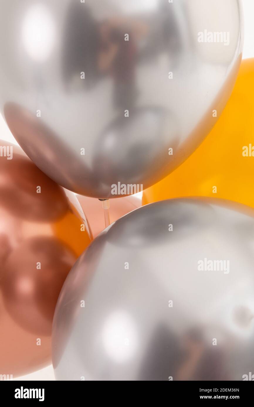 Ballons métalliques argent, or rose et or sur fond blanc Banque D'Images