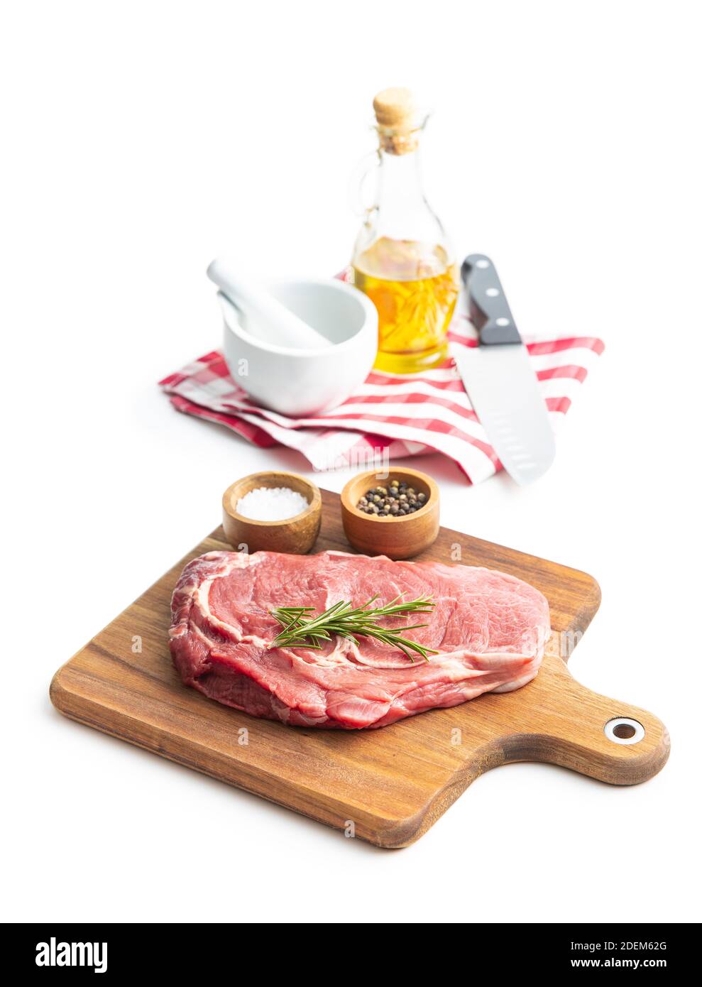 Steak de ribeye cru coupé en tranches sur une planche à découper isolée sur fond blanc. Banque D'Images