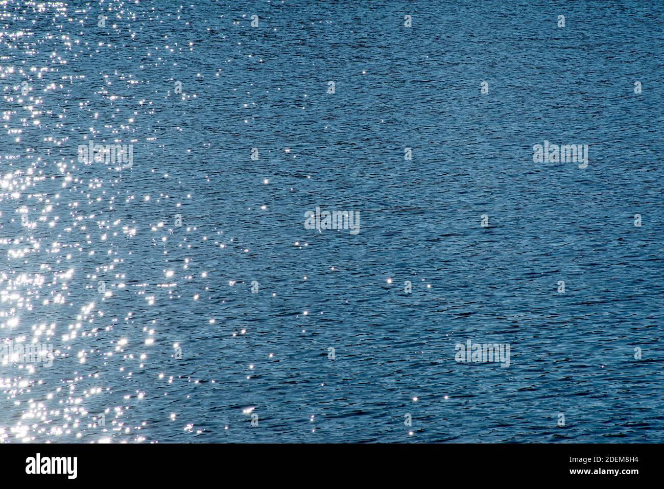 Son centre scintille sur une eau bleue calme, son image magique en plein format, dans un cadre naturel avec espace de copie. Banque D'Images