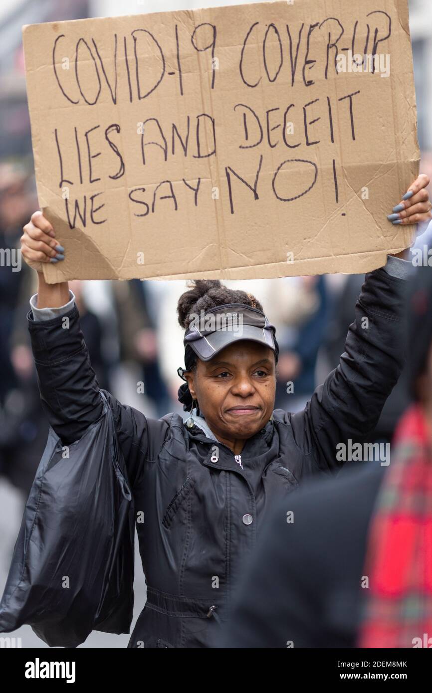 Manifestation anti-verrouillage, Londres, 28 novembre 2020. Une femme noire marchant et tenant un écriteau de protestation au-dessus de sa tête. Banque D'Images