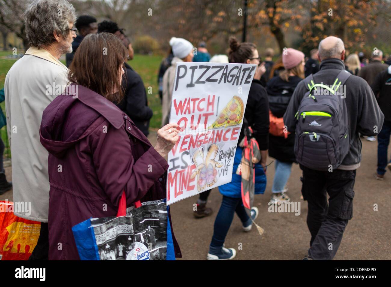 Manifestation anti-verrouillage, St James's Park, Londres, 28 novembre 2020. Un manifestant tenant un écriteau de protestation de Pizzagate. Banque D'Images