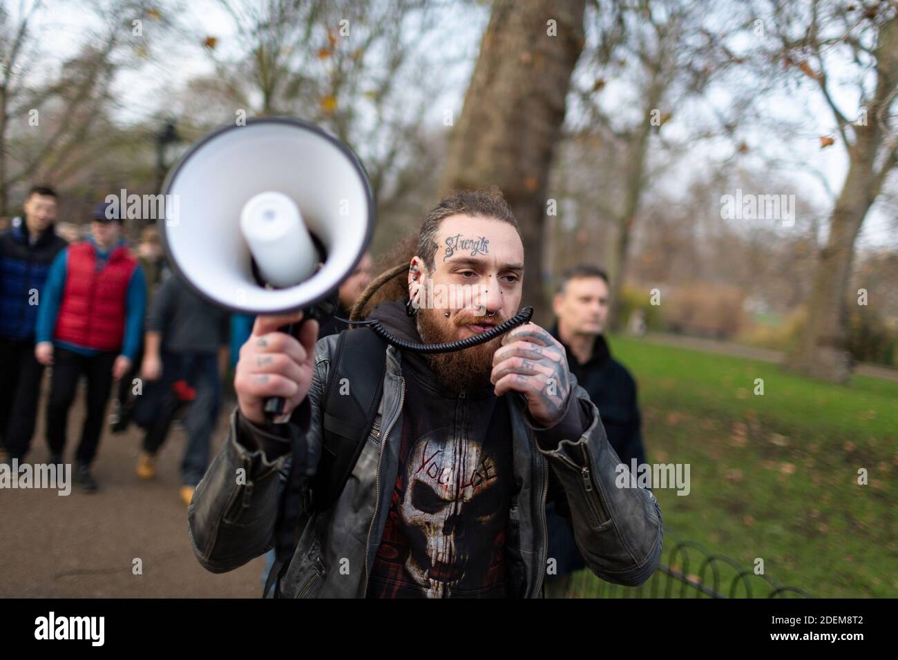 Manifestation anti-verrouillage, St James's Park, Londres, 28 novembre 2020. Un manifestant avec des tatouages et des piercings faciaux parle en mégaphone. Banque D'Images