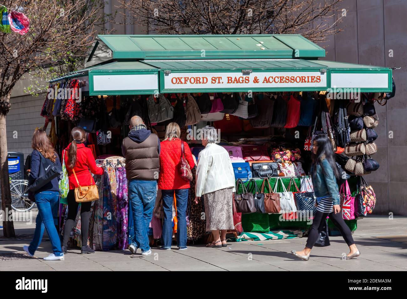 Londres, Royaume-Uni, le 1er avril 2012 : Tourisme achetant un cadeau souvenir dans un marché de rue qui vend des sacs à main en cuir et des accessoires qui ont mangé des voyages populaires Banque D'Images