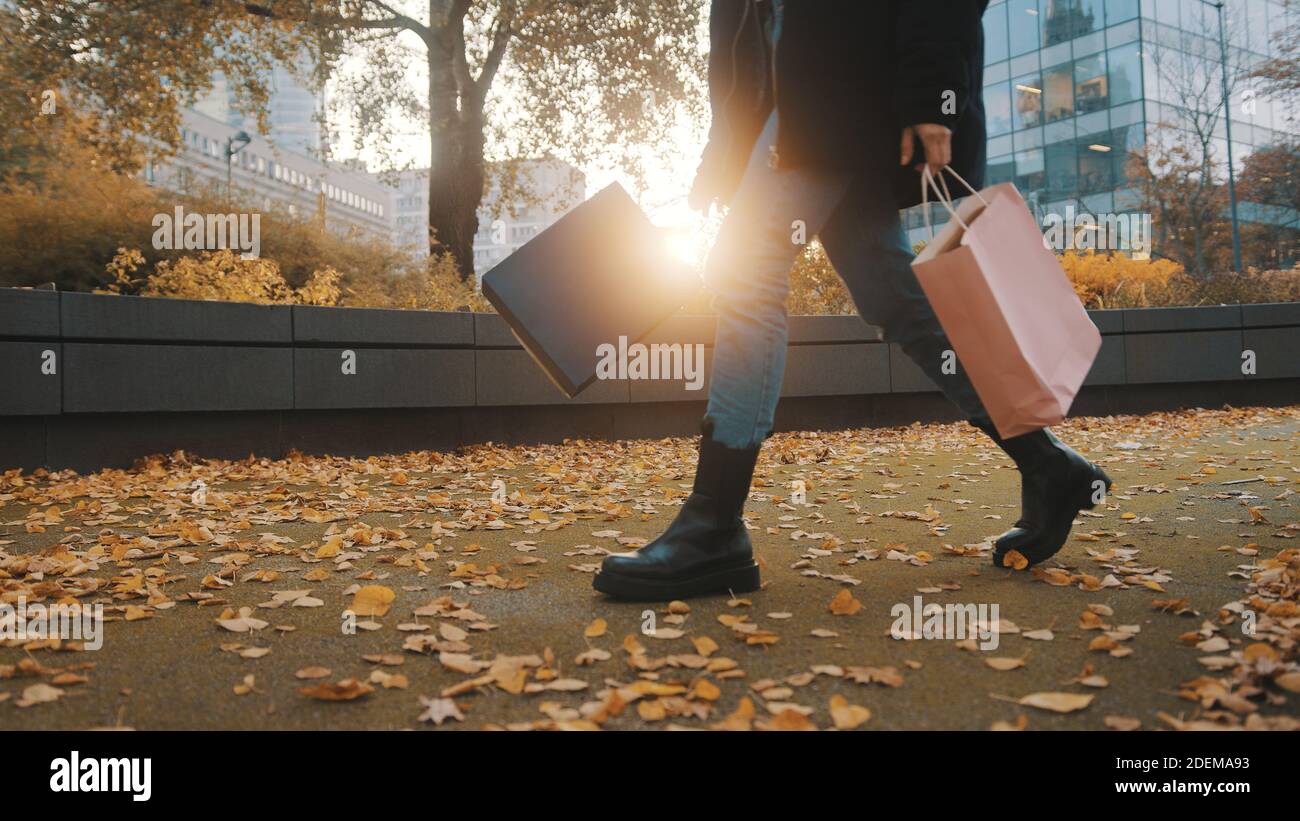 femme avec des sacs de shopping dans le parc de la ville. Shopping, saison de réductions concept. Photo de haute qualité Banque D'Images