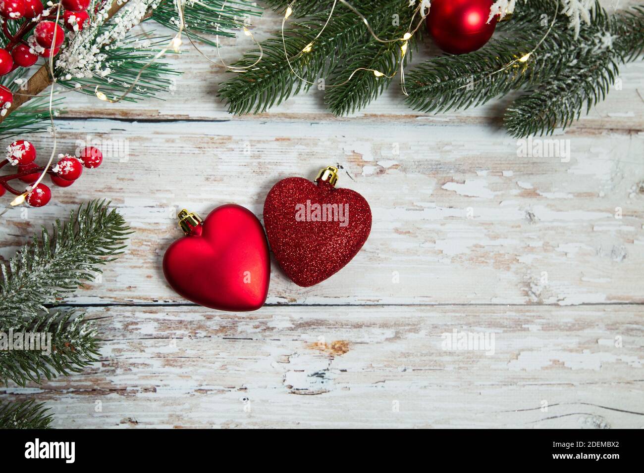 jouets rouges sous forme de coeurs sur fond de bois clair. plat de noël Banque D'Images