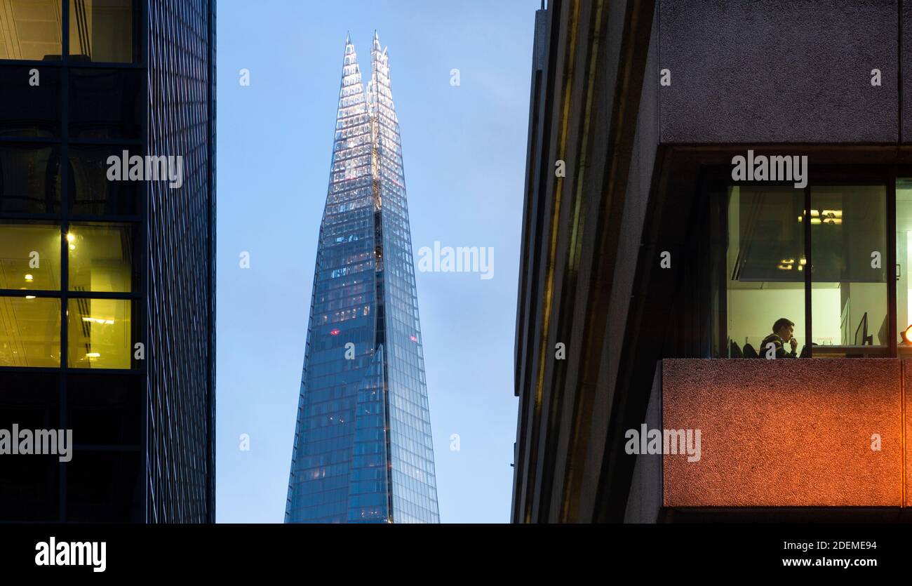 Vue à travers la fenêtre de bureau du travailleur à son ordinateur avec le Shard en arrière-plan, vu de Lower Thames Street, Londres, mars 2020 Banque D'Images