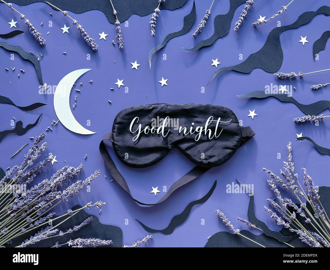 Masque de sommeil avec lavande sur fond bleu foncé avec nuages noirs, lune et étoiles Banque D'Images