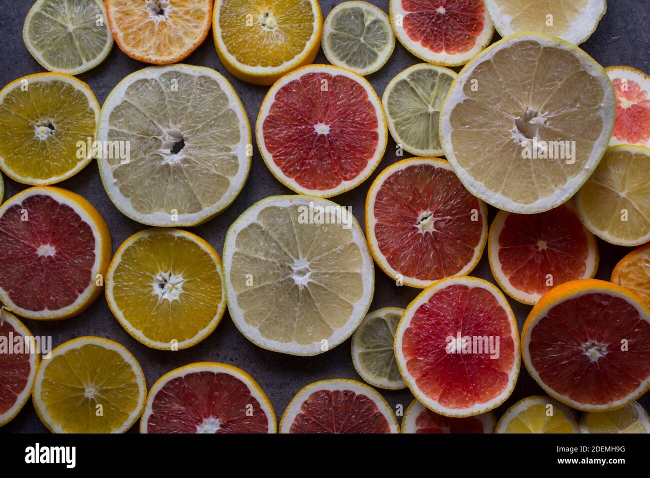 Tranches d'orange rouge sur une table. Gros plan sur la texture des fruits. Arrière-plan gris foncé avec espace de copie. Banque D'Images