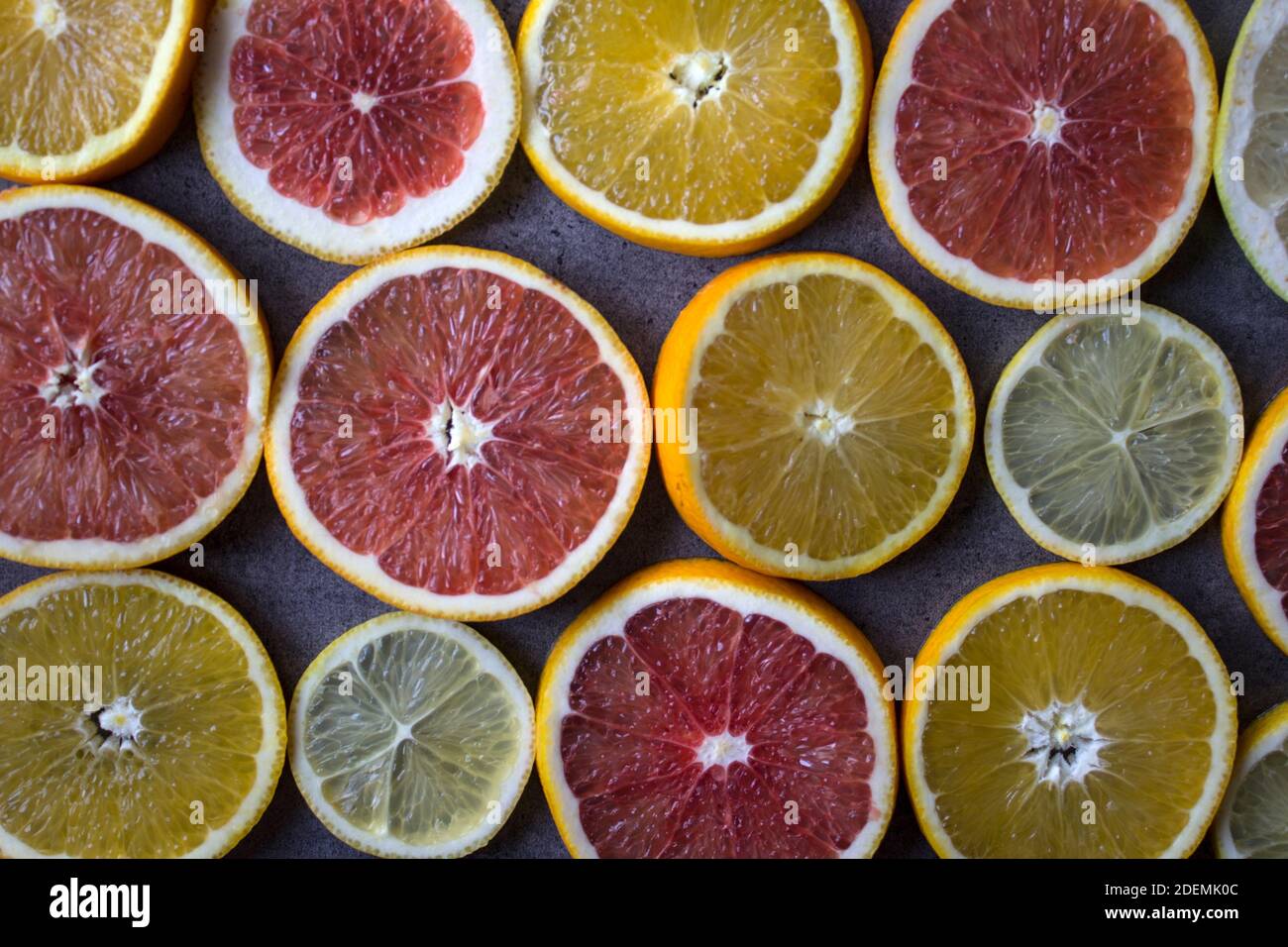 Tranches d'orange rouge sur une table. Gros plan sur la texture des fruits. Arrière-plan gris foncé avec espace de copie. Banque D'Images