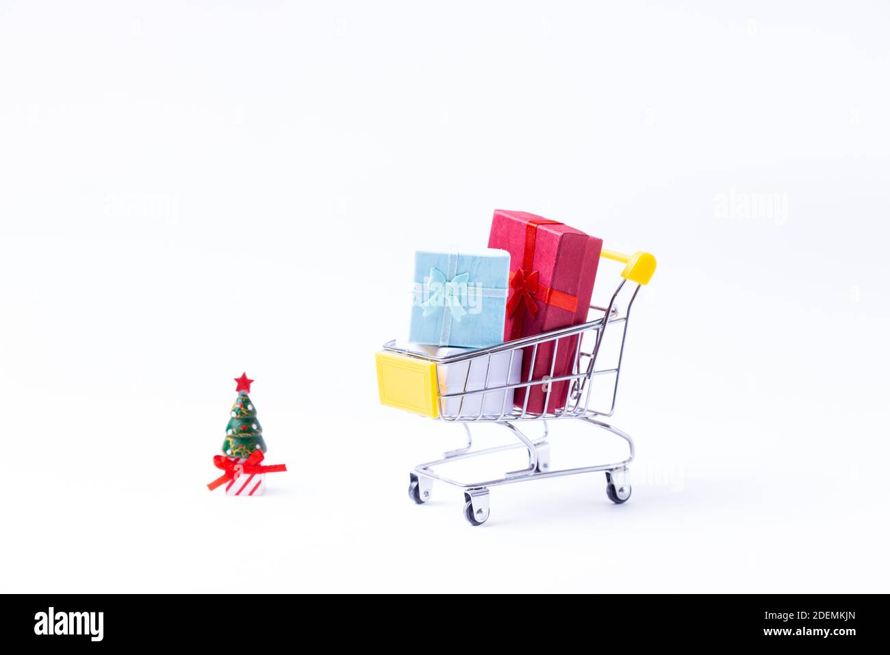 Chariot miniature avec cadeaux sur fond blanc. Concept de shopping de Noël et du nouvel an. Gros plan. Banque D'Images