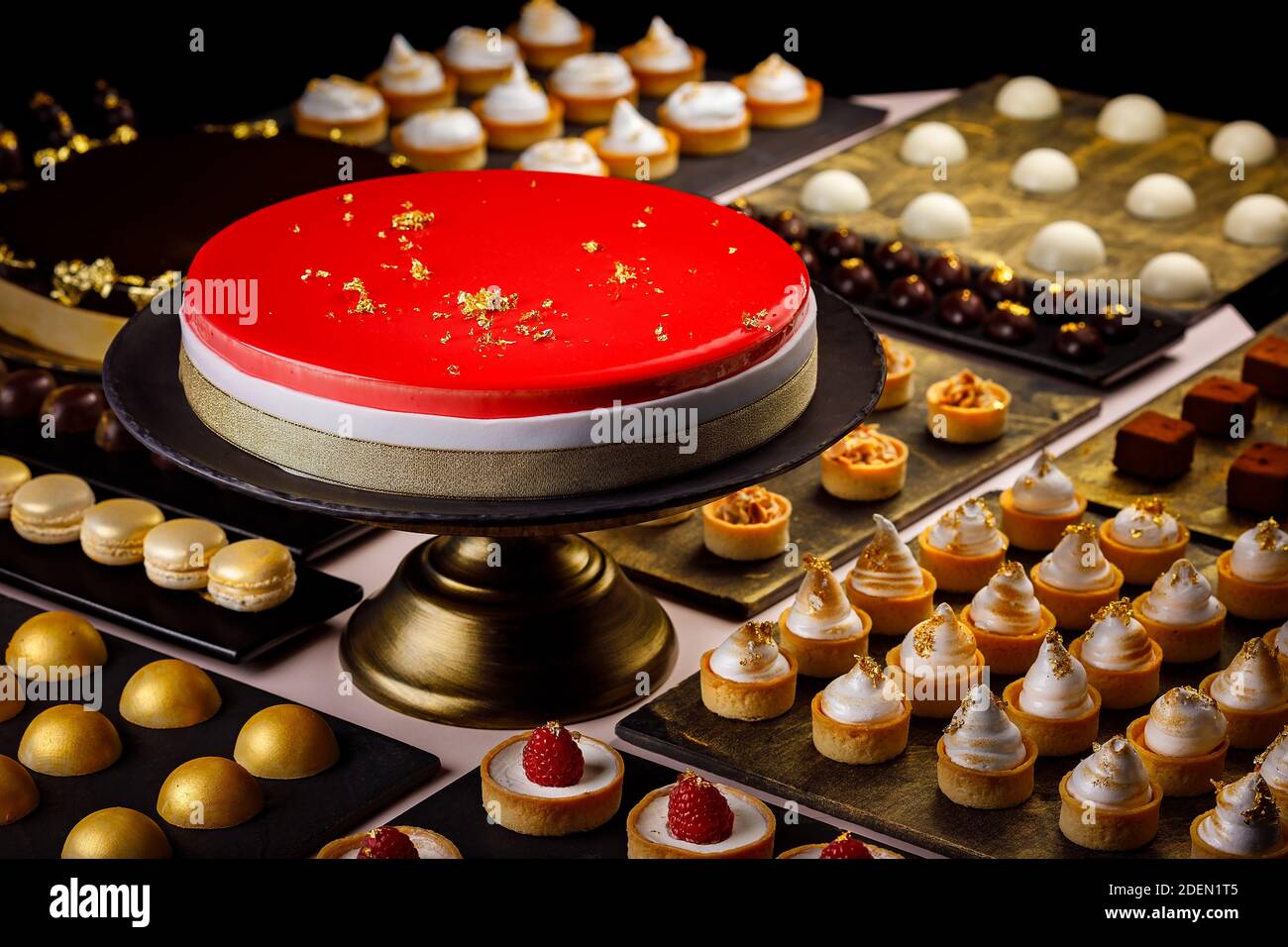 Grand gâteau aux baies servi avec une sélection de quiches, tartes, macarons et bouche d'amuse-bouche au chocolat Banque D'Images