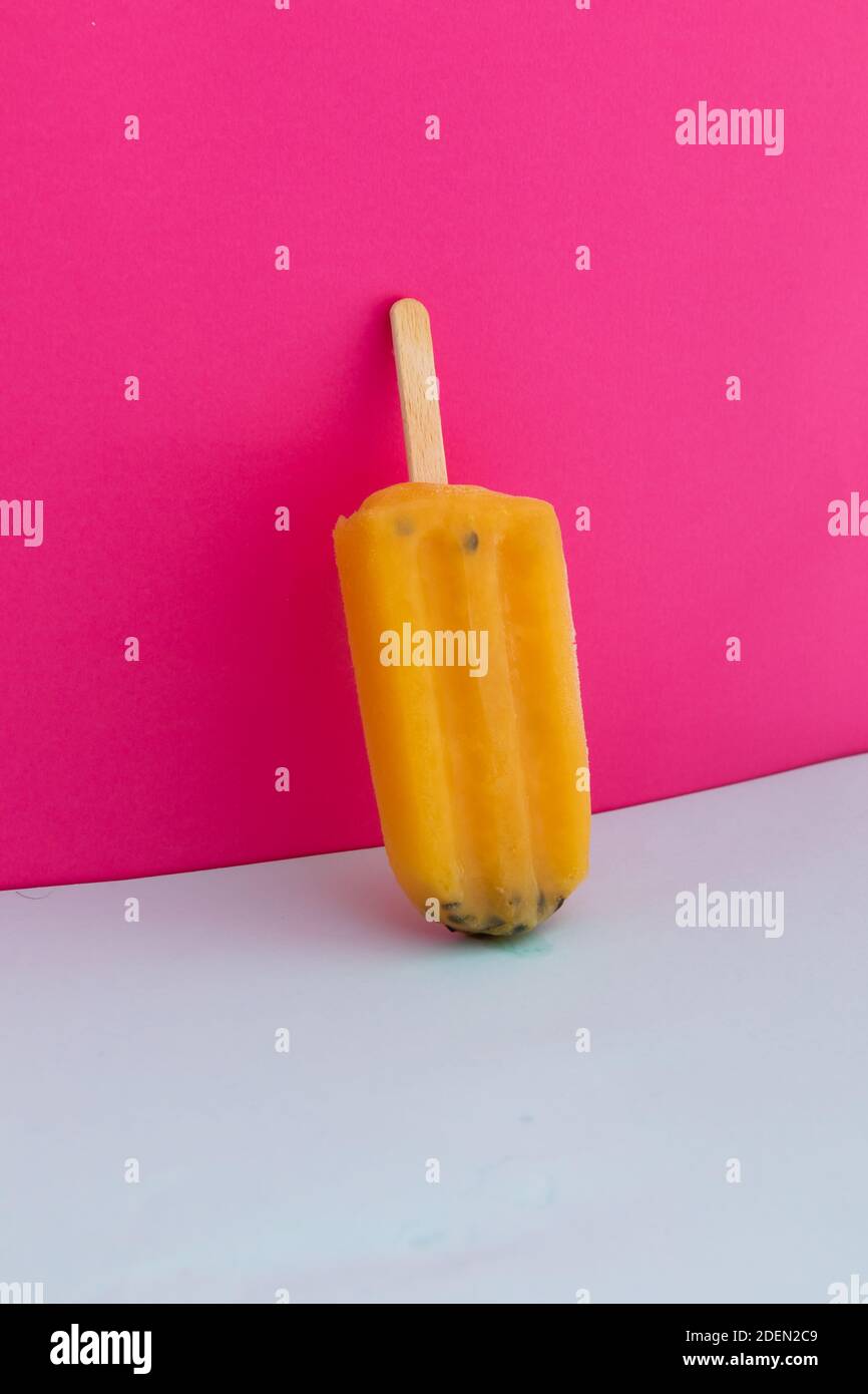 Gros plan de la glace jaune à l'envers sur le rose arrière-plan Banque D'Images