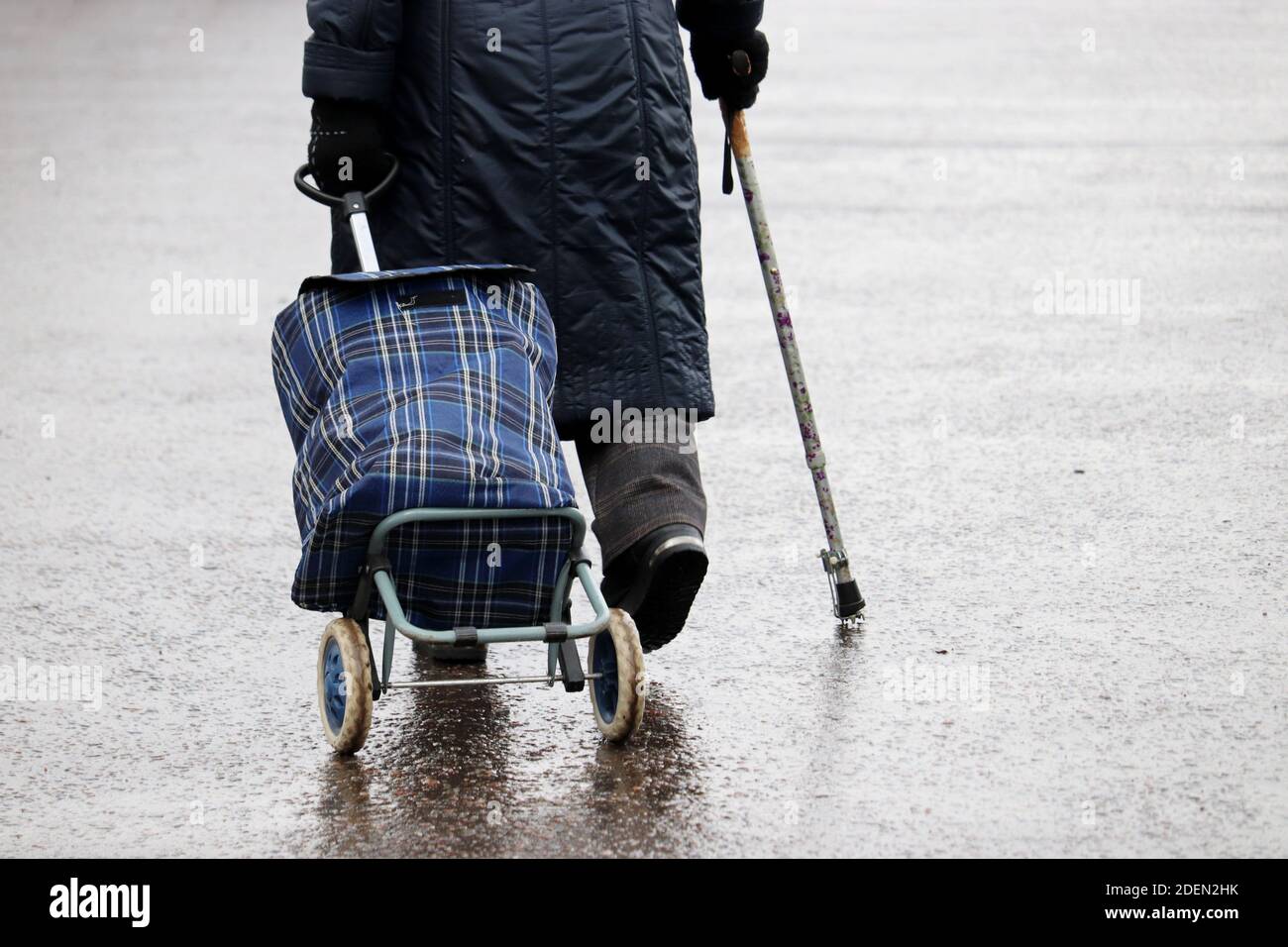 Vieille femme marchant avec une canne et un sac Banque de photographies