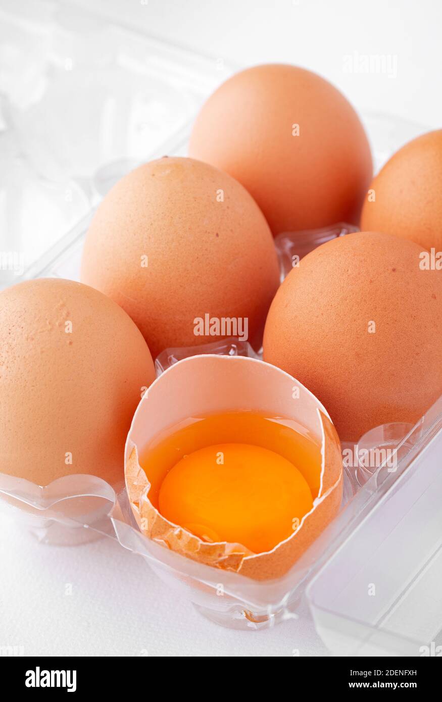 Une demi-douzaine d'œufs extra-larges gratuits avec un craquelé exposant le jaune riche Banque D'Images