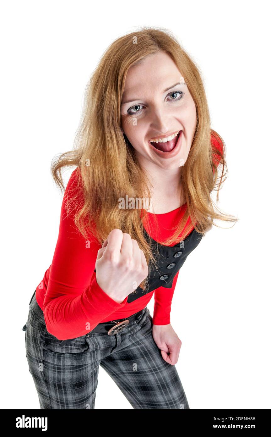 Trois quarts de longueur d'une jeune femme blonde en pantalon à carreaux,  chandail rouge et gilet noir avec sa bouche ouverte montrant le succès  poing contre blanc Photo Stock - Alamy
