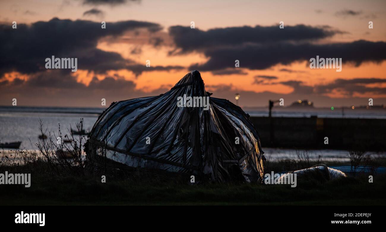 Bateau de hareng converti en hangar sur l'île Sainte de Lindisfarne donnant sur le port. Lindisfarne, Angleterre, Royaume-Uni Banque D'Images