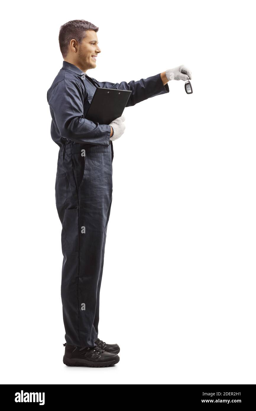 Plan de profil complet de l'employé dans un uniforme donnant clés de voiture et tenir un presse-papiers isolé sur fond blanc Banque D'Images