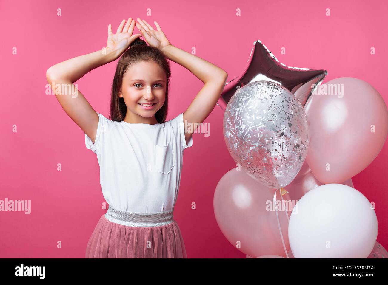 Une Fille Montre Des Oreilles De Lapin Fete D Anniversaire Sur Fond Rose Photo Stock Alamy