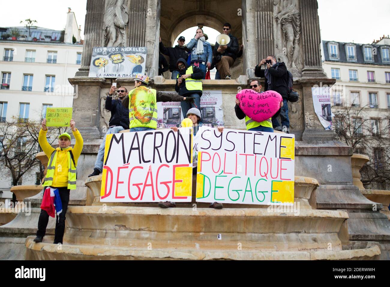 Gilets jaunes ( gilet jaune ) portant un panneau Macron Go Away ( Macron  degage ) sur la fontaine des innocents près des Halles à Paris le 17  novembre 2019, lors d'une