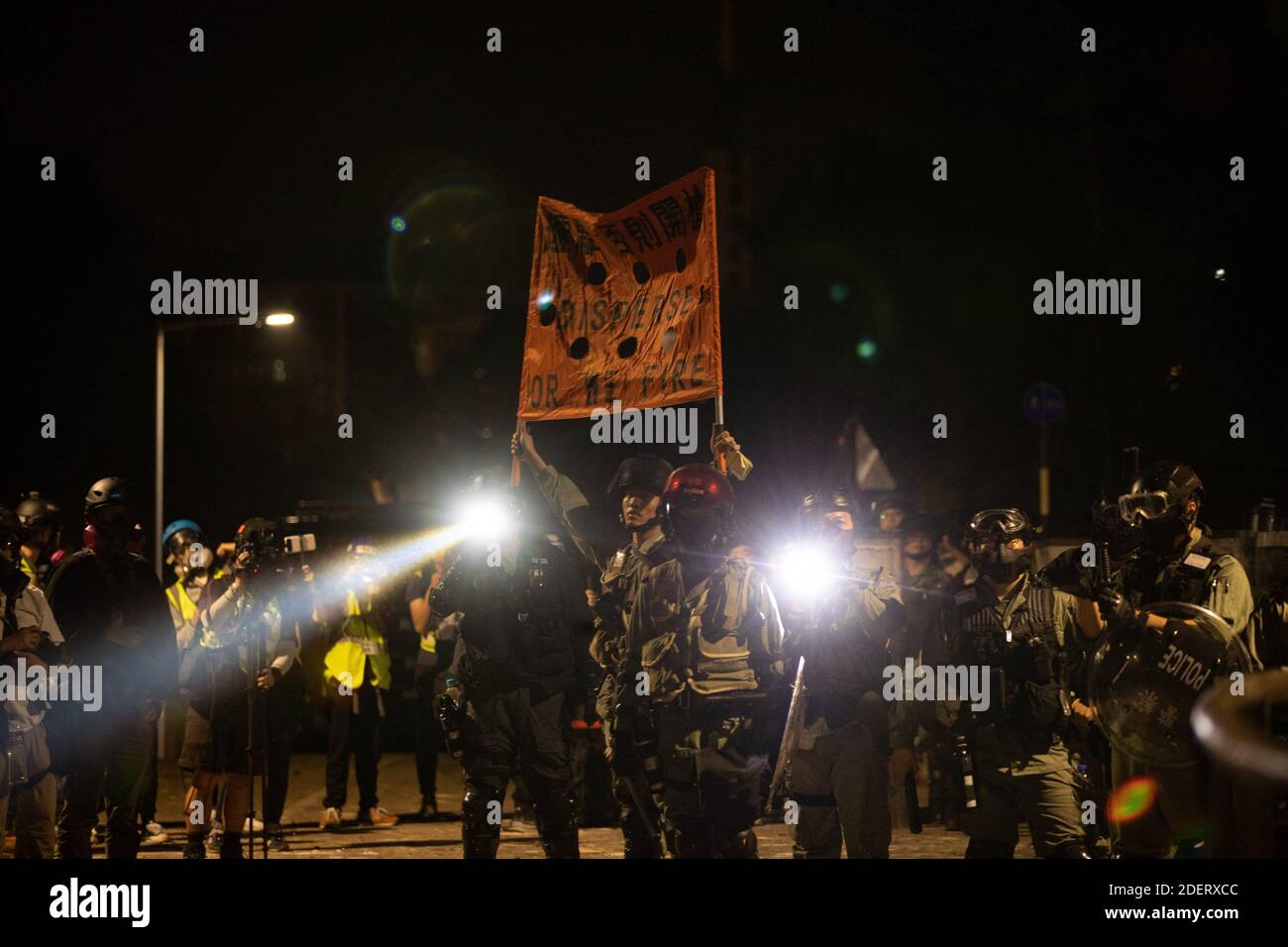 La police portant un drapeau orange a lu « Disperse or We Fire » lors du stand avec les étudiants à l'entrée de l'université. À Hong Kong, le 12 novembre 2019. Une bataille sans précédent à l'Université chinoise de Hong Kong (CUHK). La manifestation de Hong Kong se continue sur ses cinq mois. Une grève à l'échelle de la ville a débuté le lundi 11 novembre 2019, ce qui a entraîné l'arrêt de certaines parties de Hong Kong lorsque les stations MTR ont fermé et que plusieurs barrages routiers ont été érigés. Où l'autoroute Tolo Harbour sous le pont n°2 qui relie l'Université chinoise de Hong Kong (CUHK) et l'espace public est également bloquée. Photo par Banque D'Images