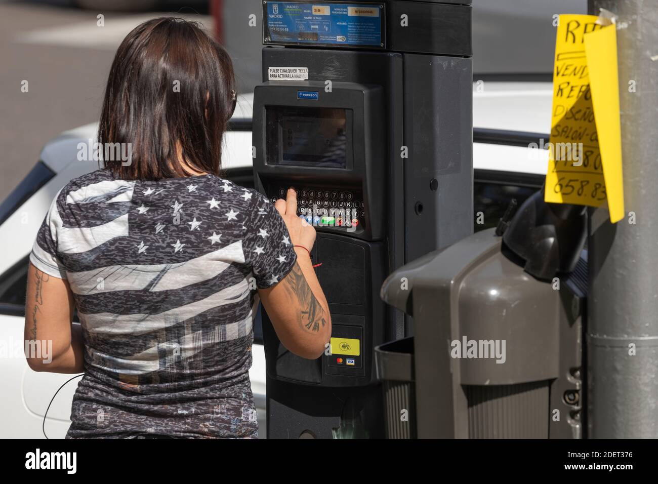 Madrid, Espagne - 26 septembre 2020 : après avoir entré le numéro de plaque d'immatriculation de la voiture, une femme paie le billet de stationnement réglementé par le Madrid c Banque D'Images