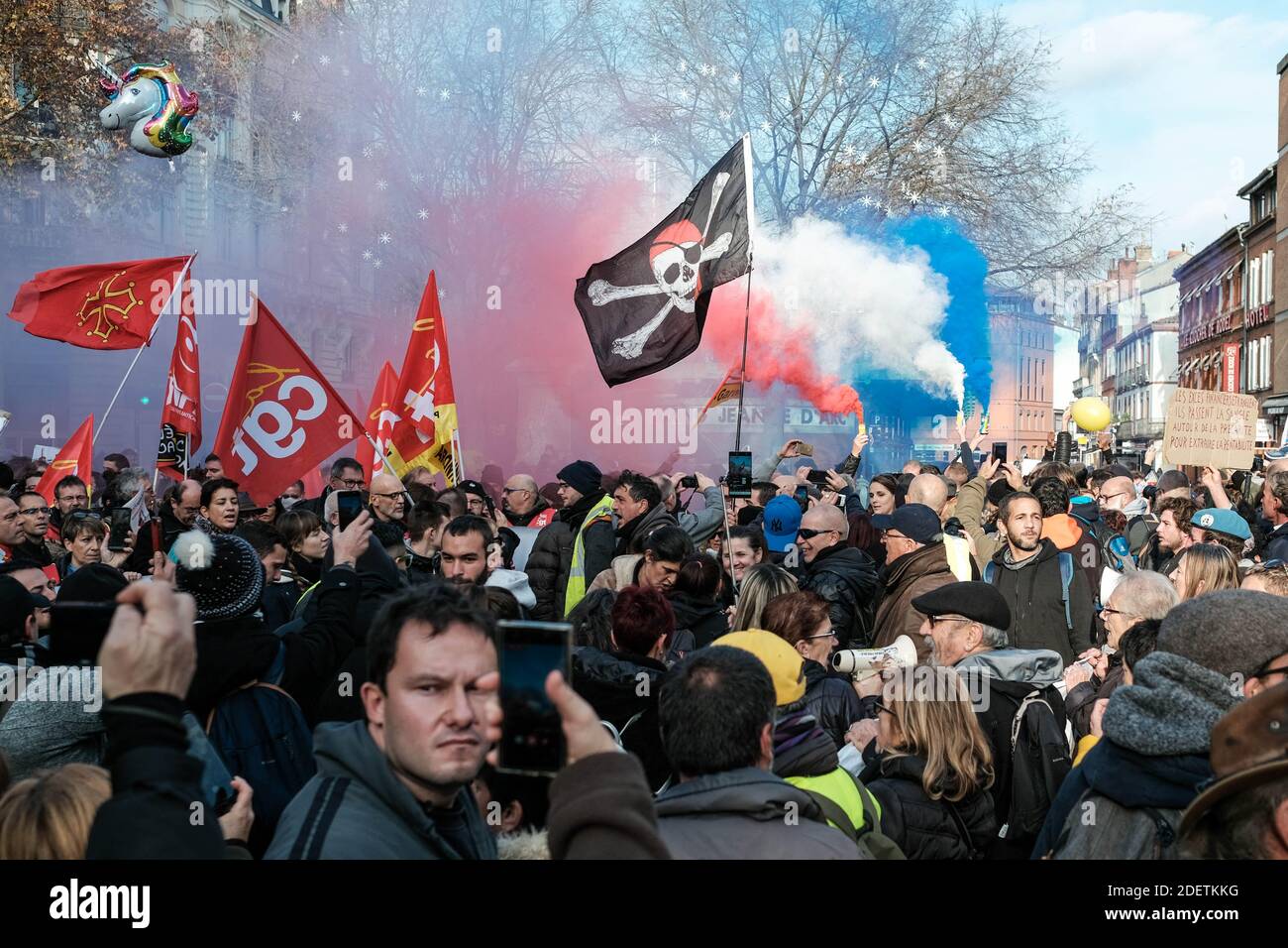 Drapeaux syndicaux CGT, drapeau pirate et fumée tricolore. Deux  manifestations de manifestants, les gilets jaunes (Gilets Jaunes) et les  syndicats, ont fusionné et défilé dans les rues de Toulouse (France), le 7