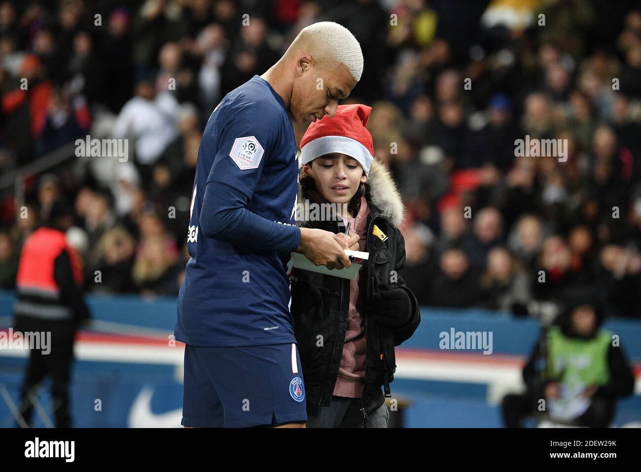 Kylian Mbappe de Paris Saint-Germain signe un autographe à un enfant qui a envahi le terrain lors du match de la Ligue 1 entre Paris Saint Germain (PSG) et Amiens au Parc des Princes le 21 décembre 2019 à Paris, France. Photo de David Niviere/ABACAPRESS.COM Banque D'Images