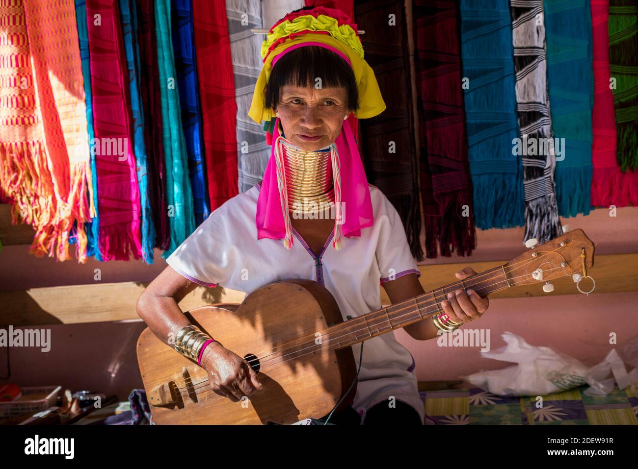 Femme birmane senior de la tribu Kayan (AKA Padaung, col long) jouant un instrument de musique semblable à la guitare, près de Loikaw, Etat de Kayah, Myanmar Banque D'Images