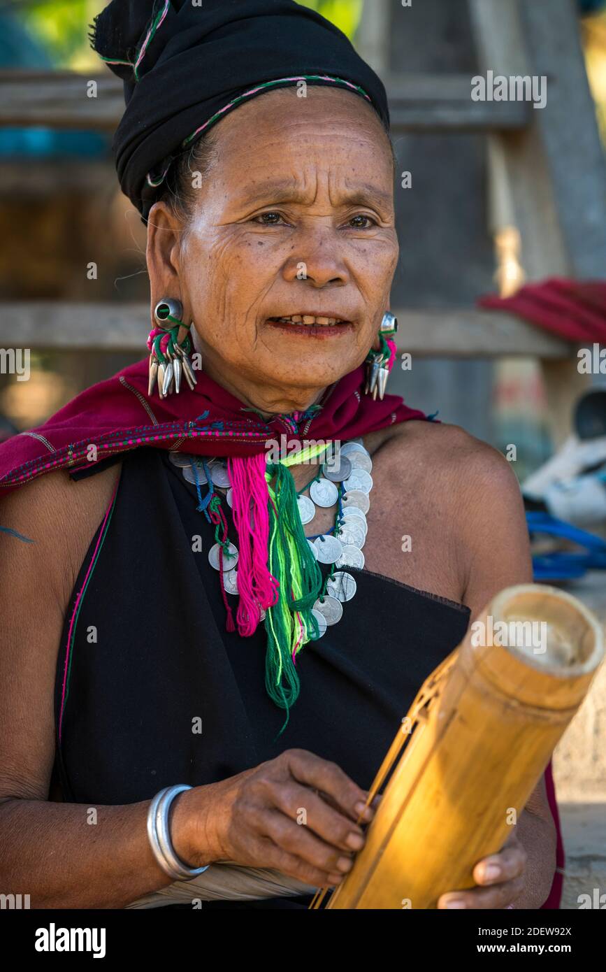 Femme adulte de la tribu Kayah jouant un instrument de musique en bambou, près de Loikaw, Myanmar Banque D'Images