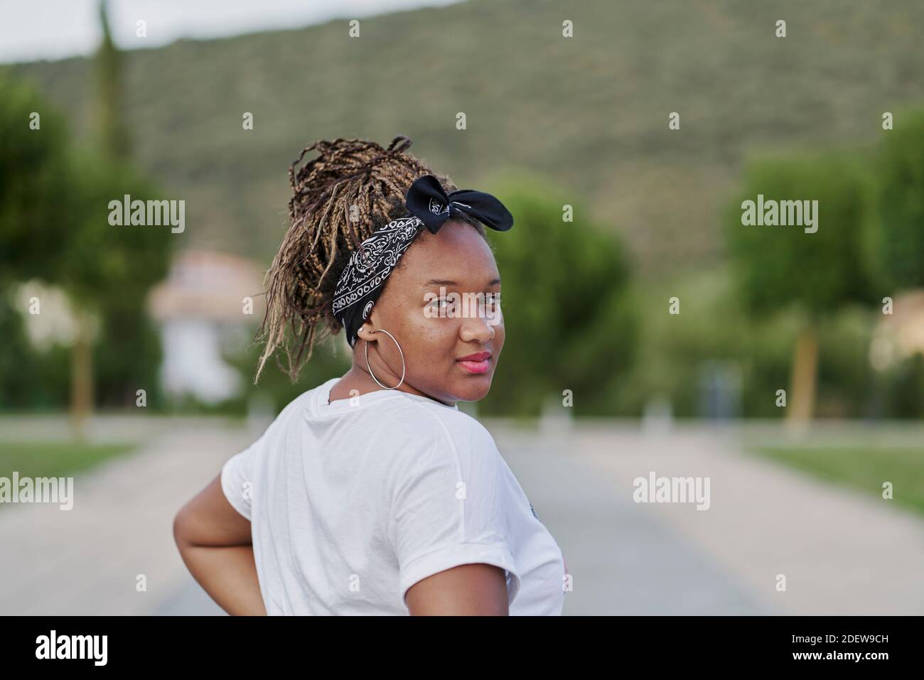 Portrait d'une fille noire avec un serre-cheveux tenant ses dreadlocks regardant de nouveau la caméra Banque D'Images