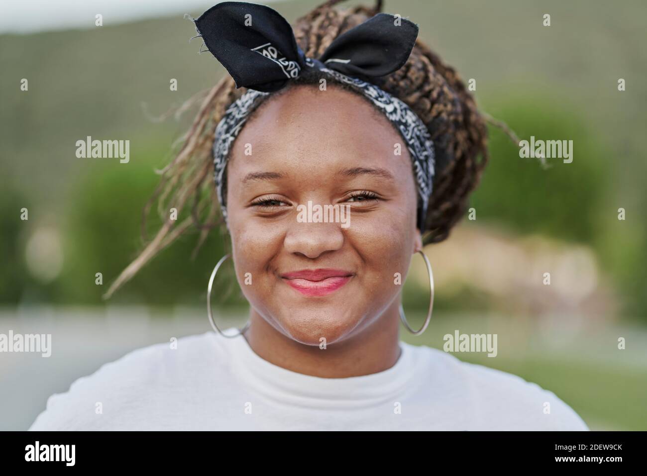 Portrait d'une fille noire avec un serre-cheveux tenant ses dreadlocks Banque D'Images