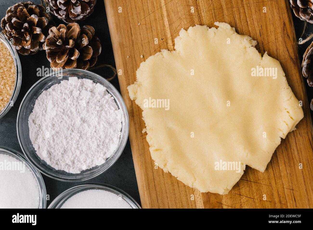 Pâte à biscuits avec pommes de pin et ingrédients sur ardoise Banque D'Images