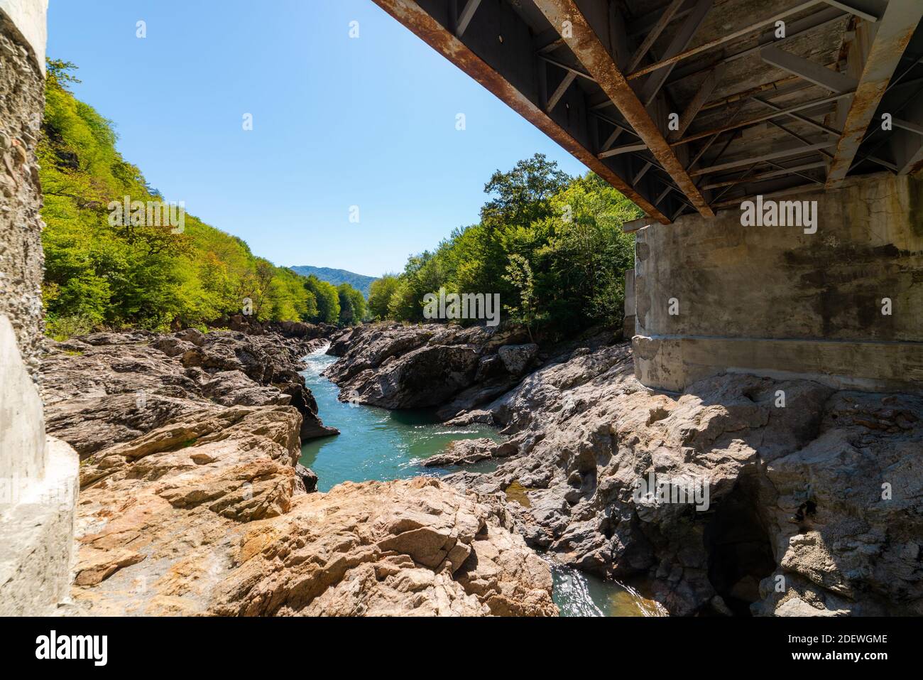 Pont en métal sur une rivière dans les montagnes vue de sous le pont. Banque D'Images