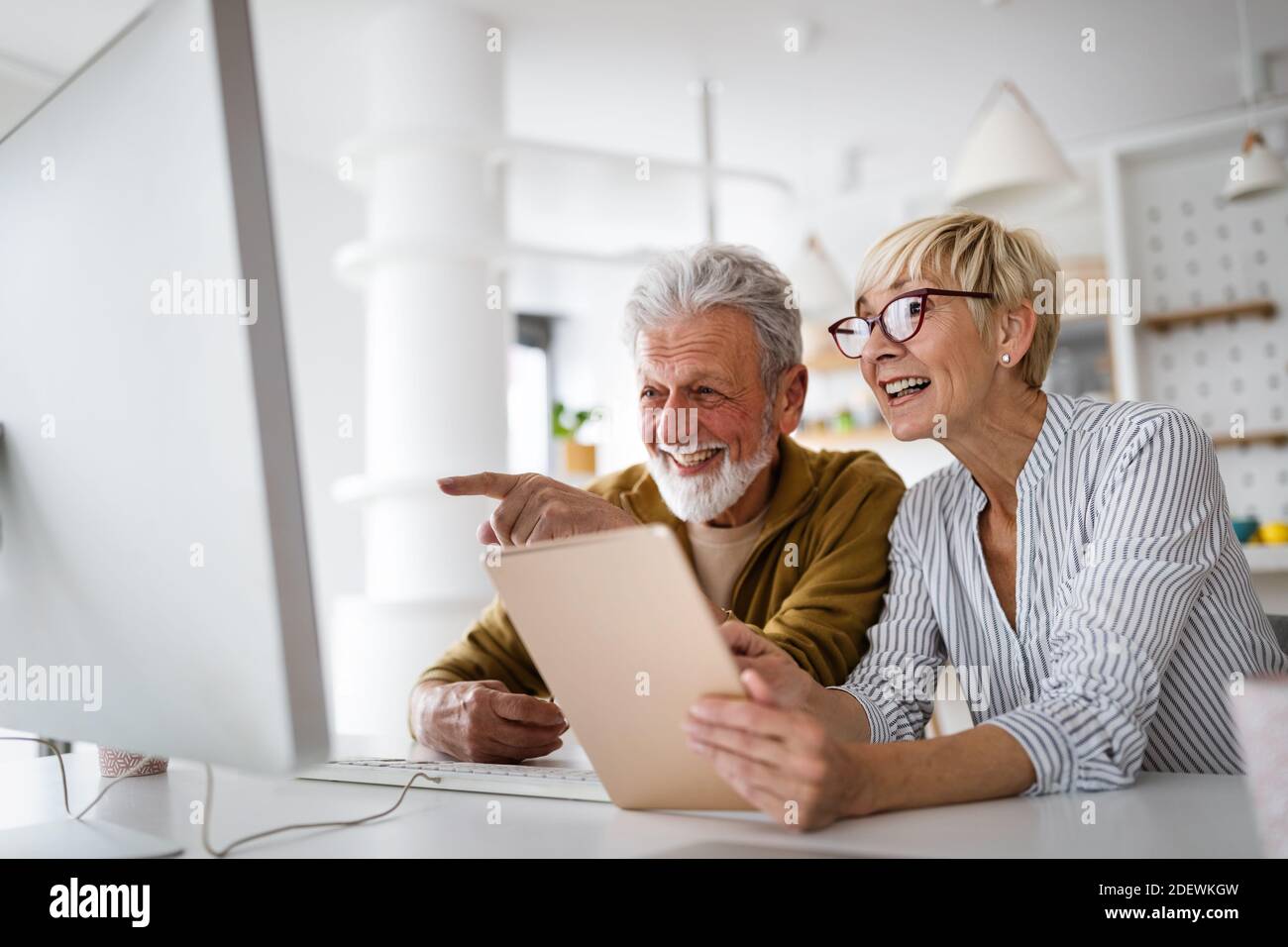 Femme âgée aidant l'homme âgé à utiliser l'ordinateur Banque D'Images