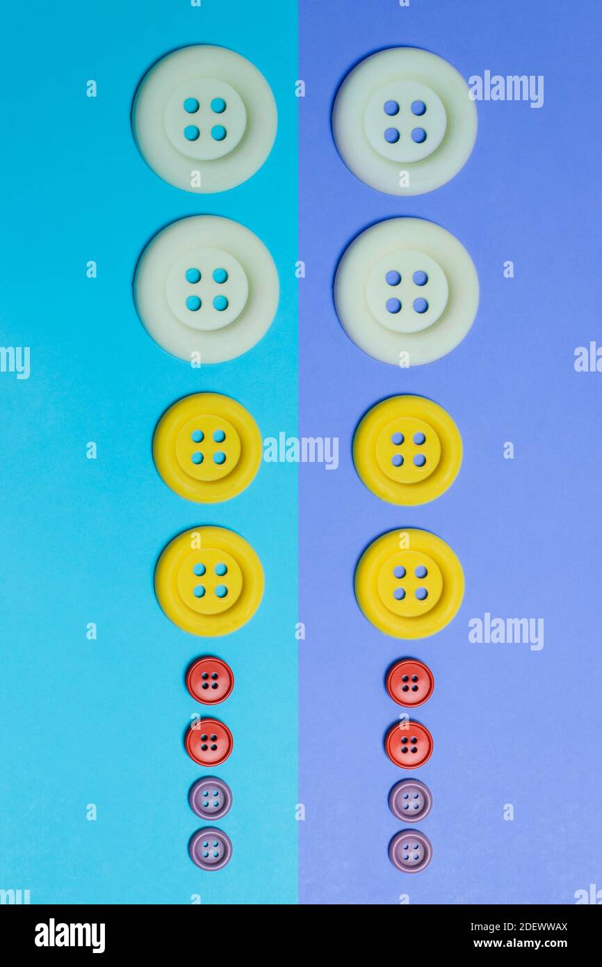 Une rangée de boutons de différentes tailles et couleurs sur un fond bicolore. Un design coloré de lignes et de cercles. Banque D'Images