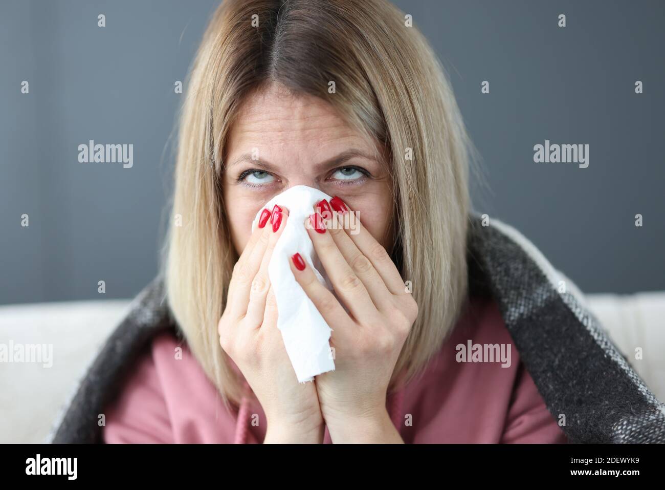 Une femme malade souffle son nez dans le mouchoir. Banque D'Images