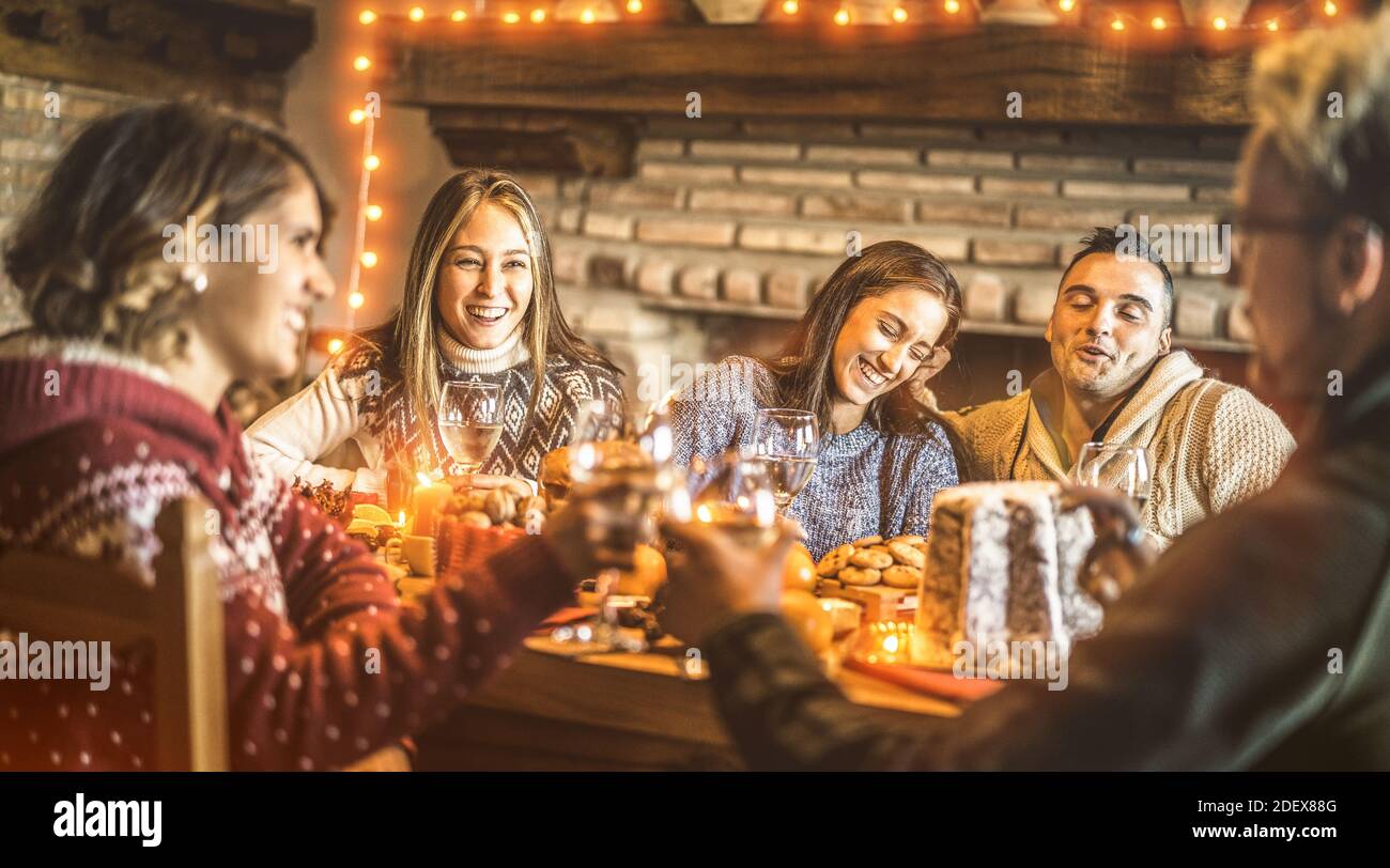 Des amis heureux goûtant des mets sucrés de noël à la maison - l'humeur de la Saint-Sylvestre avec des verres de vin blanc toast - concept de vacances d'hiver Banque D'Images