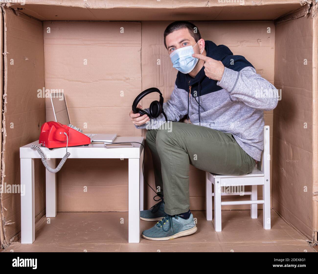 l'employé travaille depuis son propre bureau de carton pour s'isoler des autres Banque D'Images