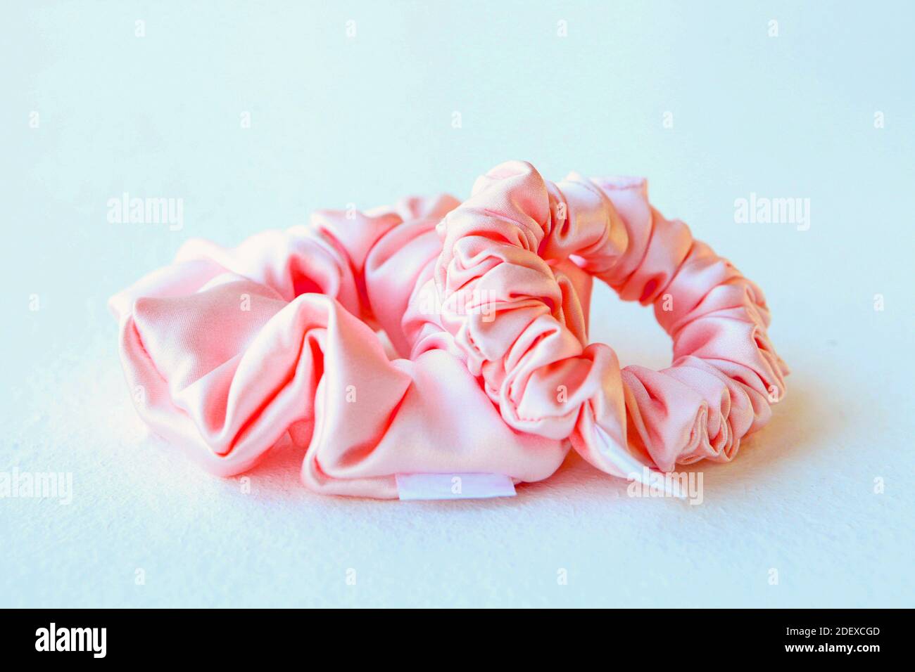 Soie rose Scrunchyes isolé sur fond blanc. Coiffeur plat de cheveux élastiques colorés, bandeau de cheveux Bobble Scrunchie Banque D'Images