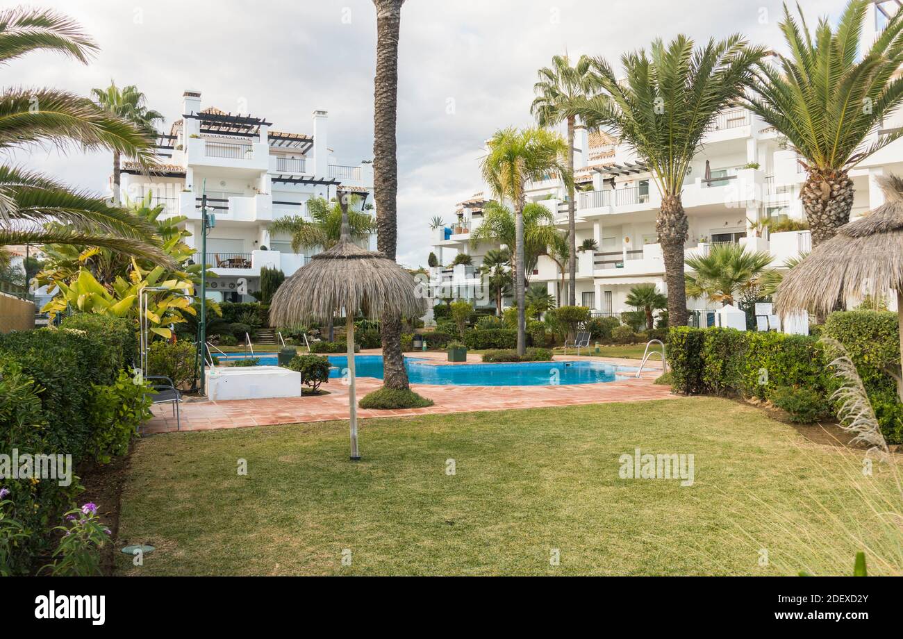 Extérieur, jardin commun et piscine d'un appartement moderne ou complexe de vacances, dans une région côtière ensoleillée, en Espagne. Banque D'Images