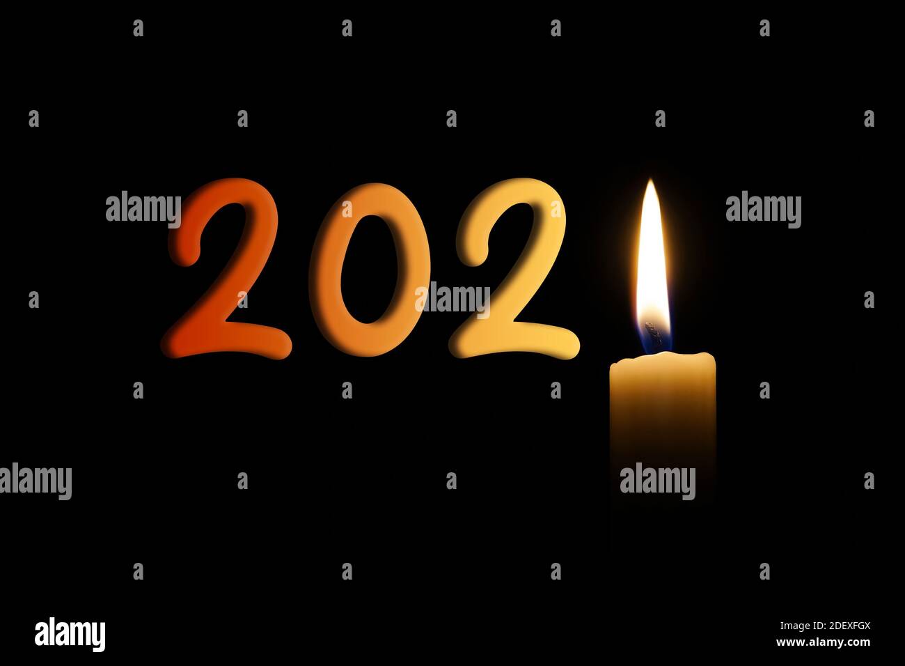 Nouvel an 2021 écrit avec une flamme de bougie éclairant l'année, isolé sur un fond noir. Banque D'Images