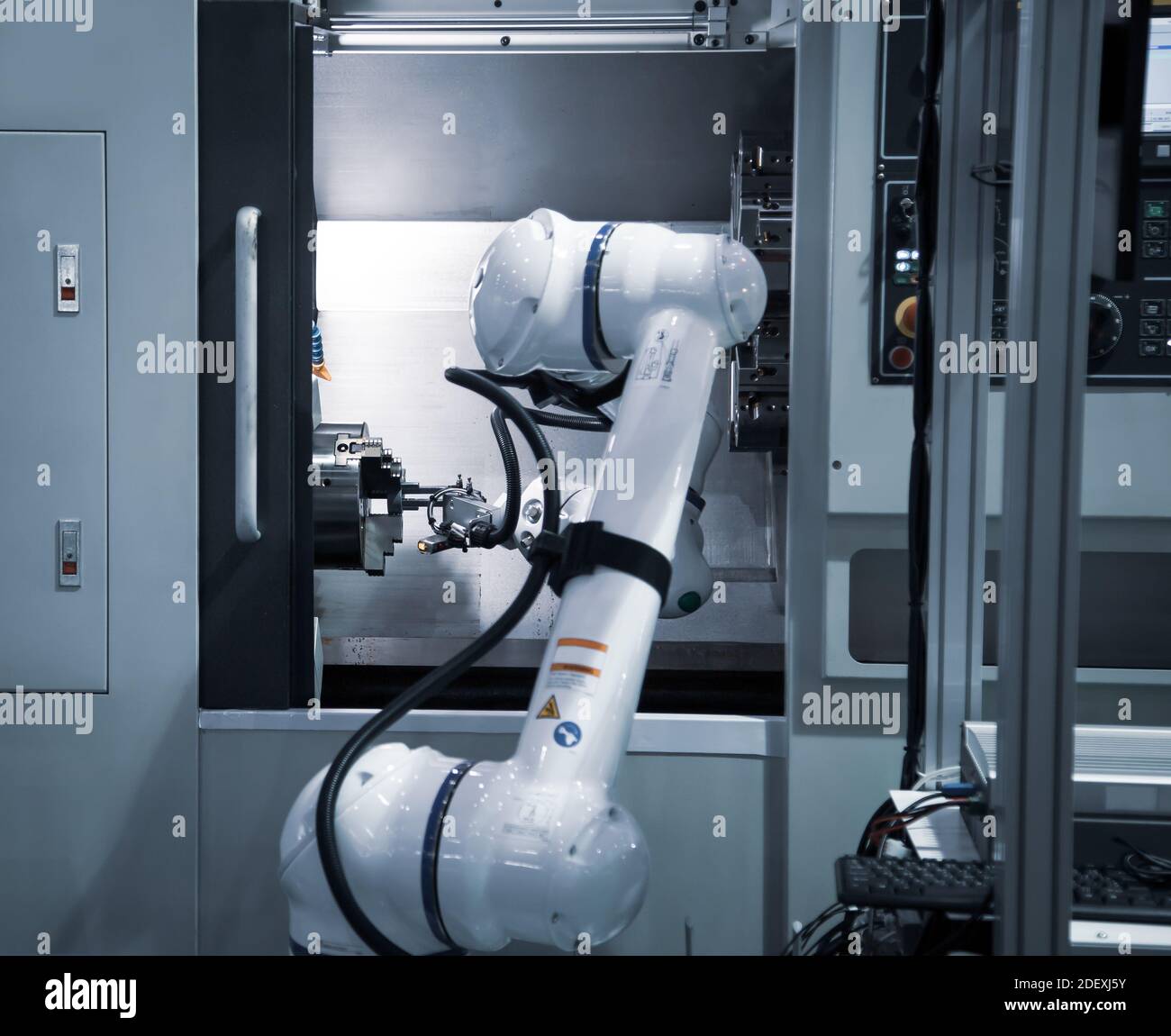 Robot industriel à processus automatisé chargeant la pièce métallique sur la machine CNC. Fabrication industrielle Banque D'Images