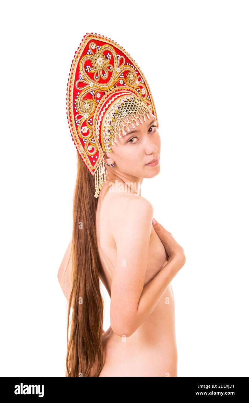 Nude souriante femme avec maquillage et coiffure dans un kokoshnik (headaddress) sur un fond blanc. Émotions en posant. Studio tourné sur fond blanc. Banque D'Images