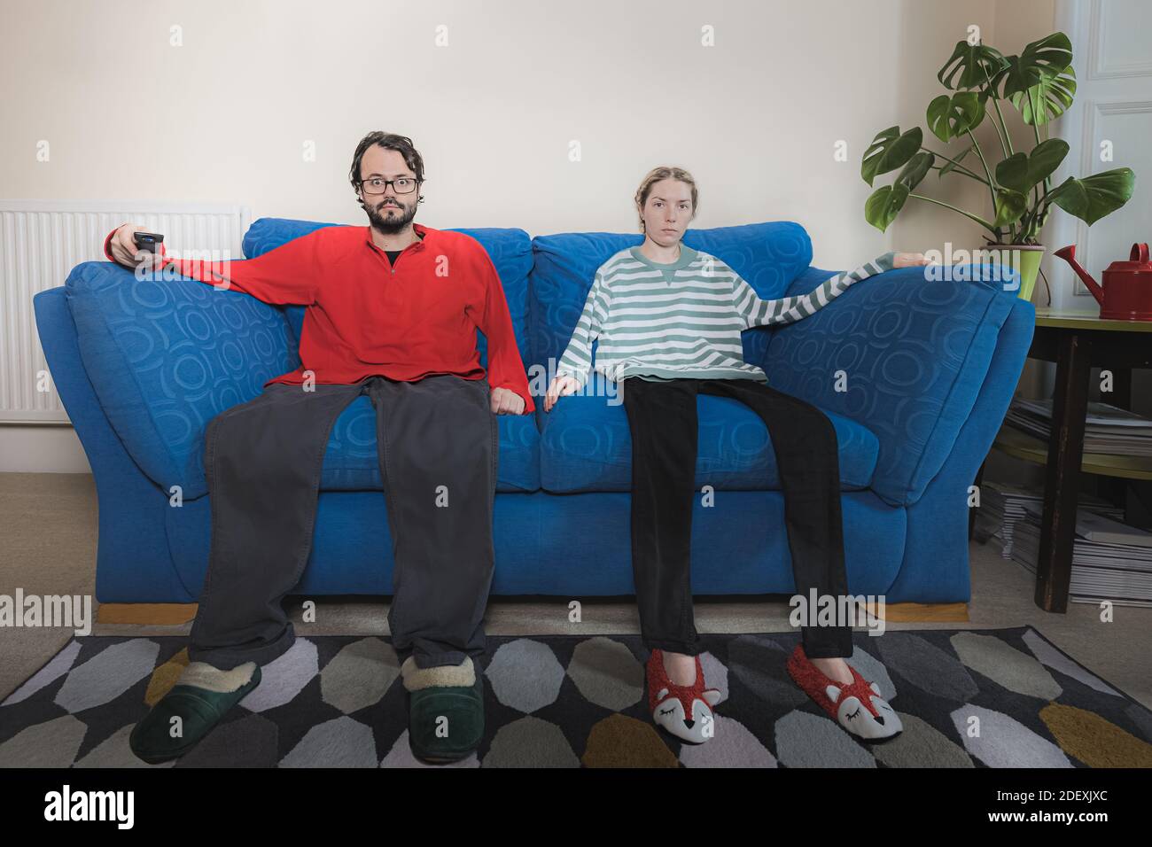 Après trop de temps à l'intérieur de la binge regarder la télévision ce couple sont devenus partie de leur canapé. Banque D'Images